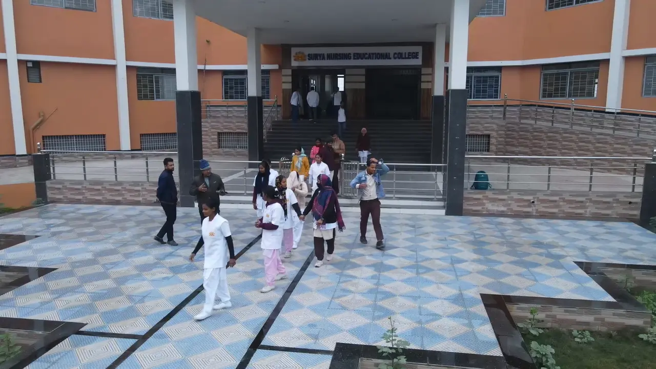 Students crossing the entrance plaza in front of the college building